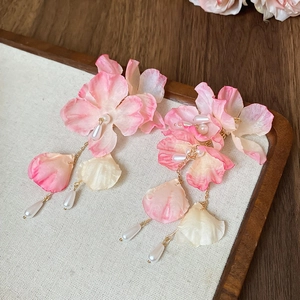 Detail of pink fabric flower earrings with long pearl tassels and gold metal chains