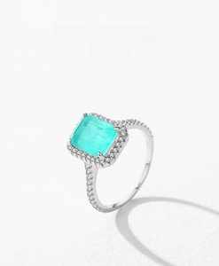 Macro detail of radiant emerald cut blue tourmaline ring with sparkling halo in silver
