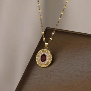 Close-up of gold-plated pendant with a red gemstone and sparkling cubic zirconia details