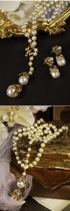 Dettaglio della collana di perle con fiori e uccelli e strass in oro vintage chic