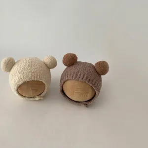 Infant winter knit earflap hats with dual pom poms and plush lining in warm colors