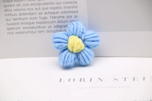Macro shot of a blue and yellow hand-knitted milk cotton flower for DIY craft accessories