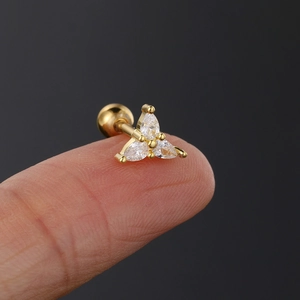 Makroaufnahme von goldener Birnen-Zirkon-Piercing-Stecker auf dem Finger zur Größensicht