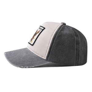 Detailed close-up of distressed brim and embroidered eagle freedom patch on baseball cap