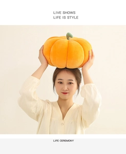 Macro shot of large orange corduroy pumpkin pillow showing texture held by a model