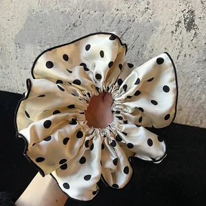 Elegant black and white polka dot satin scrunchie with a glossy silk texture for women
