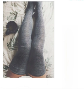 Detail of grey knitted over-the-knee socks showing texture and long thigh-high length
