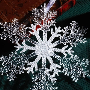 Large transparent acrylic snowflake ornament with glitter finish and purple ribbon