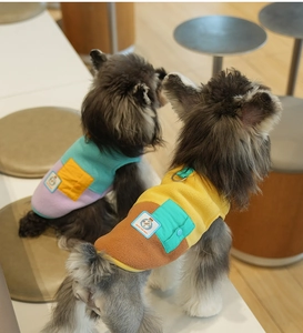 Detail view of colorful fleece dog vests with functional pockets on Schnauzer dogs