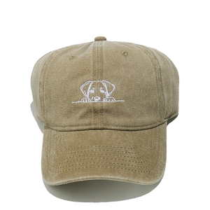 Close-up of white embroidered puppy dog on a khaki cotton baseball cap crown