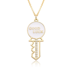 Detail of 18k gold heart key pendant with Good Luck engraving and zircon stones