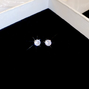 Close-up of classic round-cut zircon stud earrings with four-prong setting in silver