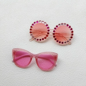 Close-up of pink kids sunglasses with sparkling rhinestones and glitter finish frames