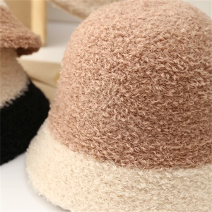 Gros plan sur la texture épaisse en peluche de ce chapeau bob d'hiver bicolore kaki et beige