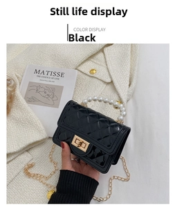 Detail of a black quilted mini silicone bag with pearl handle and gold chain strap
