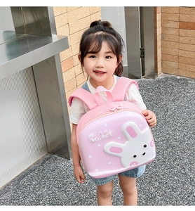 Pink hardshell toddler backpack with 3D bunny on an Asian girl in outdoor setting