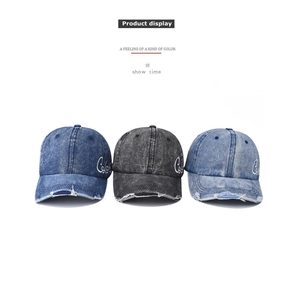 Detailed close-up of washed denim baseball caps with embroidery and distressed edges