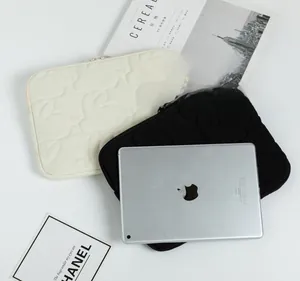 Quilted rabbit pattern tablet sleeve shown in black and beige with durable top zipper