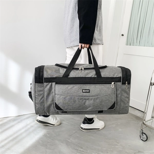 Close-up of grey waterproof nylon travel bag with SPORT logo and reinforced black handles