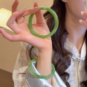 Detail view of light green resin bangle with translucent finish and minimalist design