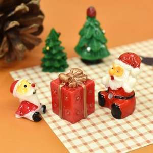 Miniature resin Christmas figurine set with Santa Claus, gift box, and green trees