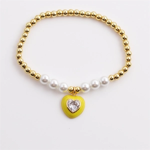 Gold beaded bracelet with white pearls and a yellow enamel heart pendant with zircon
