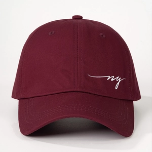 Detailed close-up of wine red cotton baseball cap with white NY embroidery and eyelets