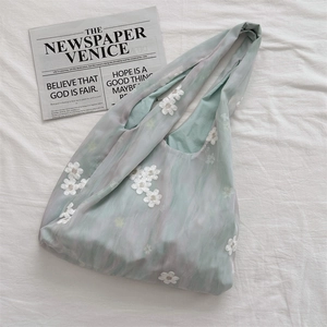 Detailed embroidery on light green organza tote bag with delicate white floral patterns