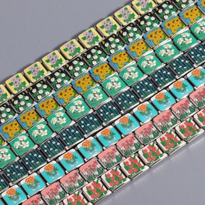 Detail of Italian style stainless steel modular charms with colorful enamel floral designs