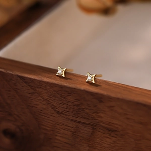 Macro shot of S999 sterling silver four-point star stud earring with inlaid zircon stone