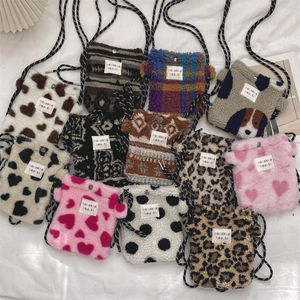 Macro view of plush mini crossbody bags with heart and leopard patterns and woven straps