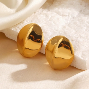 Polished gold oval geometric earrings on stone and silk background for women