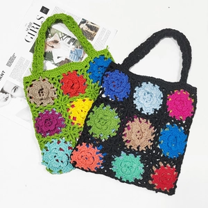Detail of colorful crochet flower handbags in green and black on white surface