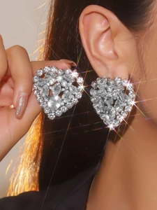 Macro shot of oversized heart-shaped crystal earrings with sparkling starburst effect