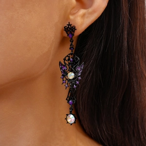 Detail of gothic dark style butterfly drop earrings with purple enamel and crystals