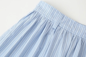 Close-up of blue vertical striped skirt waist with belt loops and pleated cotton texture