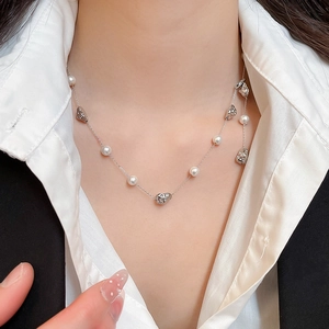 Detailed close-up of French vintage pearl necklace with irregular silver accents on a model