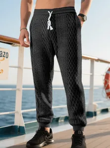 Men's black textured casual joggers with drawstring waist and cuffed hems on deck