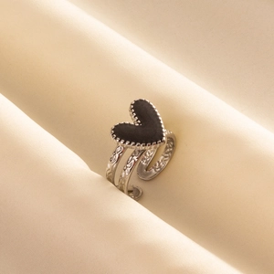 Macro detail of silver ring with black heart inlay and vintage textured adjustable band