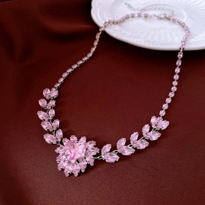 Detail der rosa Kristall-Herz-Halskette mit floralen Schliffsteinen und Silberkette