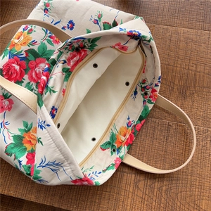 Top view of quilted floral tote bag showing smooth zipper closure and spacious interior