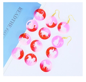 Détail de 12 pendentifs zodiaque en résine avec dégradé rose rouge et paillettes dorées