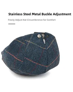 Detail of adjustable stainless steel buckle on navy herringbone wool newsboy cap