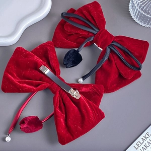 Detail of red velvet bow hair clips with pearls and rhinestones on a metal clip