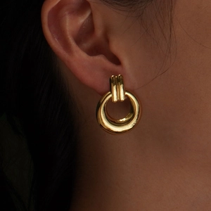 Close-up of minimalist golden circular earrings in polished stainless steel for women