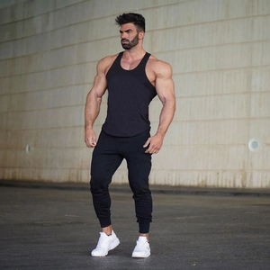 Detail of slim fit black athletic jogger pants and tank top for men's fitness training