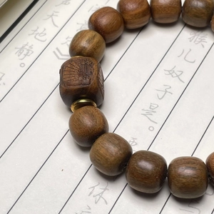 Bracelet de perles en bois de santal foncé avec entretoises dorées et perles gravées