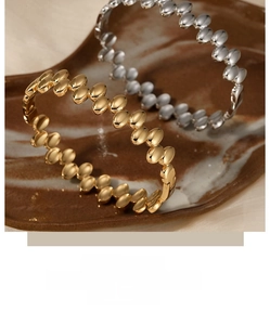 Detail shot of gold and silver beaded link bracelets on a marble texture display tray