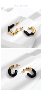 Detail view of French retro black and gold stainless steel C-shaped stud earrings