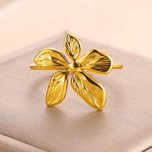 Macro shot of gold floral ring with twisted band and textured five-petal design